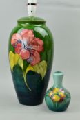 TWO MOORCROFT POTTERY LAMP BASES, larger lamp 'Hibiscus' pattern on green ground, paper label to