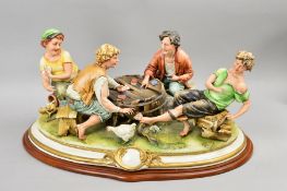 A CAPODIMONTE FIGURE GROUP, 'The Cheat', on plinth, width approximately 50cm, (fingers missing off