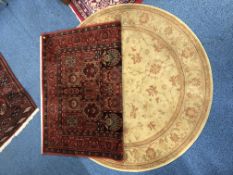 A MODERN RUG, red ground and foliate detail, together with a modern circular ground rug (2)
