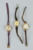 THREE EARLY 20TH CENTURY WATCHES, with 9ct gold heads and leather straps, head diameters 21mm to