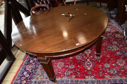 AN EARLY 20TH CENTURY MAHOGANY WIND OUT DINING TABLE, on square reeded tapering legs, acanthus
