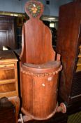 A STAINED HARDWOOD CHILDS HIGH CHAIR, on wheels