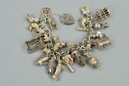 A CHARM BRACELET, the curb link bracelet suspending twenty seven charms, to include a treasure chest