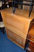 AN ERCOL STYLE OAK FALL FRONT BUREAU, above a single drawer and cupboard (sd)