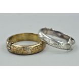 TWO HINGED SILVER BANGLES, the first with applied leaf and bird decoration to the half bangle,