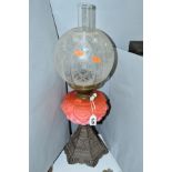 A LATE VICTORIAN OIL LAMP, acid etched glass shade, pink glass reservoir on a hexagonal cast iron