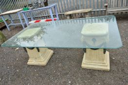 A GLASS TOPPED GARDEN TABLE, with two stone effect plastic column supports, approximate size