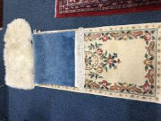 A CHINESE RUG, cream ground, another rug and a sheepskin rug (3)