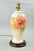 A MOORCROFT POTTERY LAMP BASE, 'Hibiscus' pattern on cream ground, mounted on a wooden plinth,