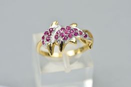 A 9CT GOLD RUBY AND DIAMOND DOLPHIN RING, designed as two leaping dolphins pave set with circular