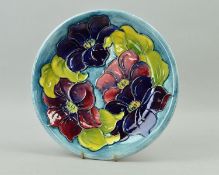 A MOORCROFT POTTERY PLATE 'Clematis' pattern on light blue ground, impressed marks and painted