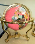 A MODERN BRASS MOUNTED PINK TERRESTRIAL TABLE TOP GLOBE, in a gimbal mount