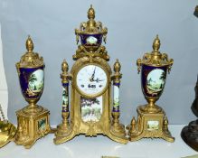 A REPRODUCTION BRASS AND PORCELAIN CLOCK GARNITURE, the enamel dial with Roman numerals, eight day