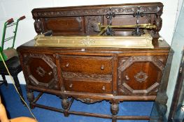 AN EARLY 20TH CENTURY CARVED OAK SIDEBOARD, with a raised two drawer central to two cupboard doors