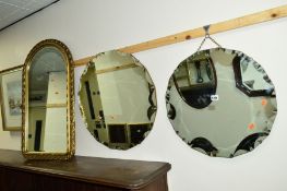 A MODERN CIRCULAR WALL MIRROR, with shaped edging, a matching smaller circular mirror and a gilt