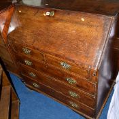 A GEORGE III OAK AND MAHOGANY BANDED FALL FRONT BUREAU, the fitted interior with carved oak drawer