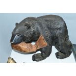 A CARVED WOODEN FIGURE OF A BEAR WITH A FISH IN ITS JAWS, height 19cm