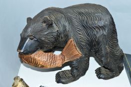 A CARVED WOODEN FIGURE OF A BEAR WITH A FISH IN ITS JAWS, height 19cm