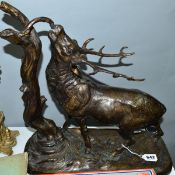 A 20TH CENTURY BRONZE OF A STAG BY A TREE STUMP, approximate height 41.5cm