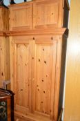 A TALL PINE TWO DOOR WARDROBE, with a single drawer and detachable top section, approximate size