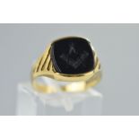 A 9CT GOLD ONYX MASONIC SIGNET RING, the central onyx panel carved with a square and compasses to