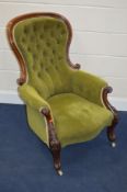 A VICTORIAN WALNUT BUTTONED SPOON BACK ARMCHAIR, with green velour upholstery and a scrolled