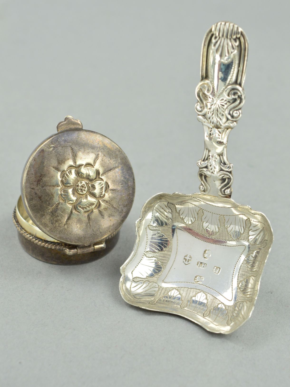 A SILVER GEORGIAN CADDY SPOON AND A PILL BOX, the caddy spoon with scrolling detail to the handle