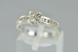 A DIAMOND RING, designed as four central princess cut diamonds to the channel set brilliant cut