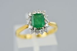 AN 18CT GOLD EMERALD AND DIAMOND CLUSTER RING, designed as a central rectangular cut emerald