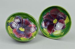 TWO SMALL MOORCROFT POTTERY FOOTED BOWLS, 'Clematis' pattern on a green ground, impressed marks to