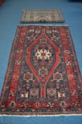 A 20TH CENTURY CAUCASION STYLE RED AND BLUE GROUND RUG, 212cm x 125cm, together with a modern rug (