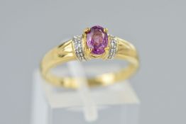 A 9CT GOLD GEM RING, designed as a central gem, assessed as a garnet, flanked by two circular