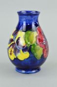 A SMALL MOORCROFT POTTERY BULBOUS VASE, 'Hibiscus' pattern on blue ground, paper label to base,