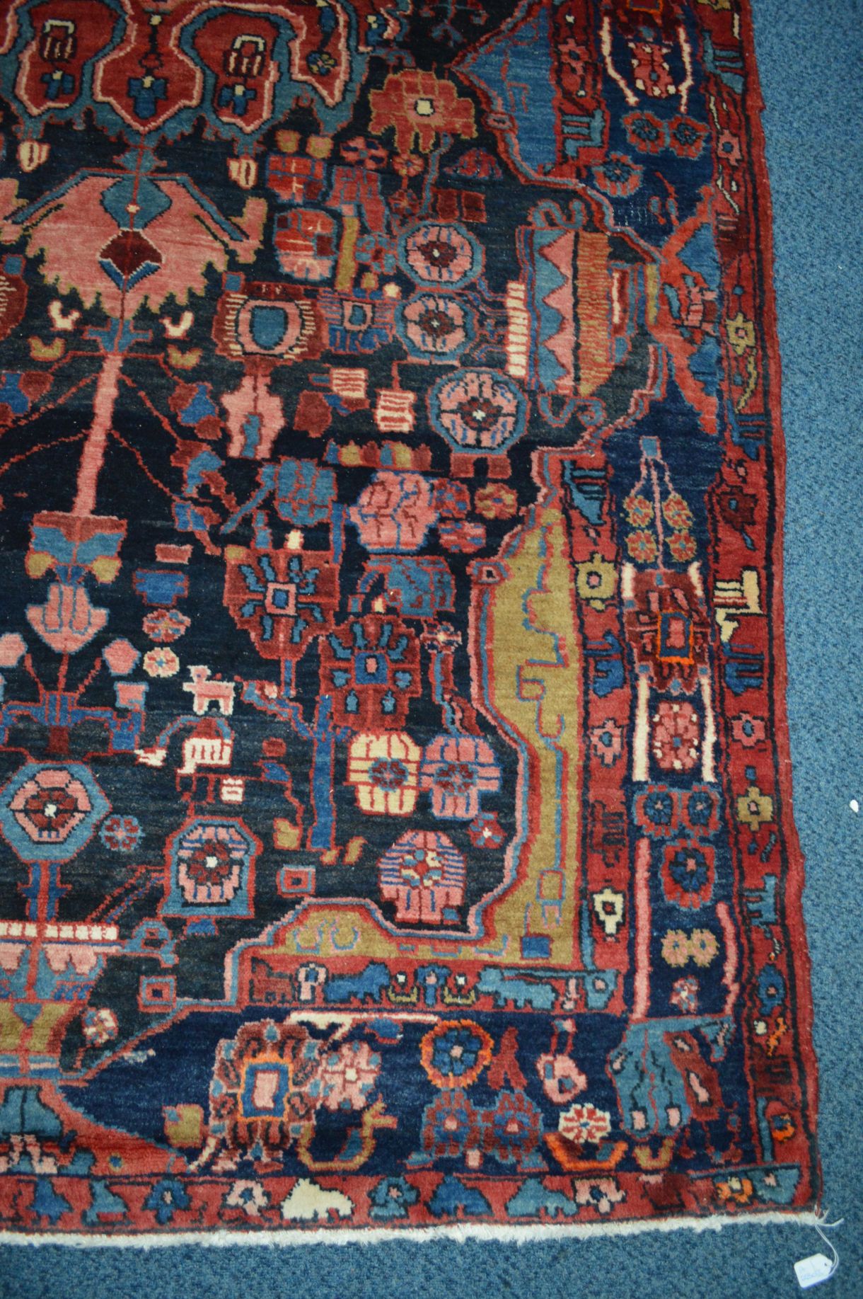 A 20TH CENTURY RED AND BLACK GROUND WOOLLEN CARPET SQUARE, with foliate and animal designs, (heavily - Image 2 of 4