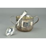 A SILVER EDWARDIAN PORRINGER AND SPOON, the double handled porringer of hammered design with