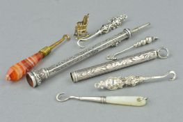 TWO EDWARDIAN SILVER RETRACTABLE PENCILS, FIVE BUTTON HOOKS AND A CHARM, the retractable pencils