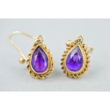 A PAIR OF 9CT GOLD AMETHYST DROP EARRINGS, each designed as a suspended pear shape amethyst within a