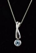 A MODERN 9CT WHITE GOLD BLUE TOPAZ SINGLE STONE DROP PENDANT, cross over design polished and satin