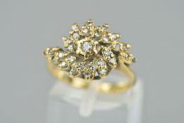 A 9CT GOLD DIAMOND DRESS RING, designed as a central brilliant cut diamond within a cluster, cross-