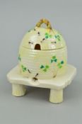 A BELLEEK HONEY POT AND COVER, in the form of a wicker skep on a stand, black printed mark rubbed,