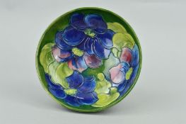 A MOORCROFT POTTERY FOOTED BOWL, 'Clematis' pattern on green ground, impressed and painted