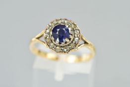 A SAPPHIRE AND DIAMOND CLUSTER RING, the central circular sapphire within a rose cut diamond
