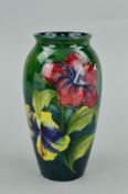 A MOORCROFT POTTERY VASE, 'Hibiscus' pattern on green ground, impressed and painted backstamp and
