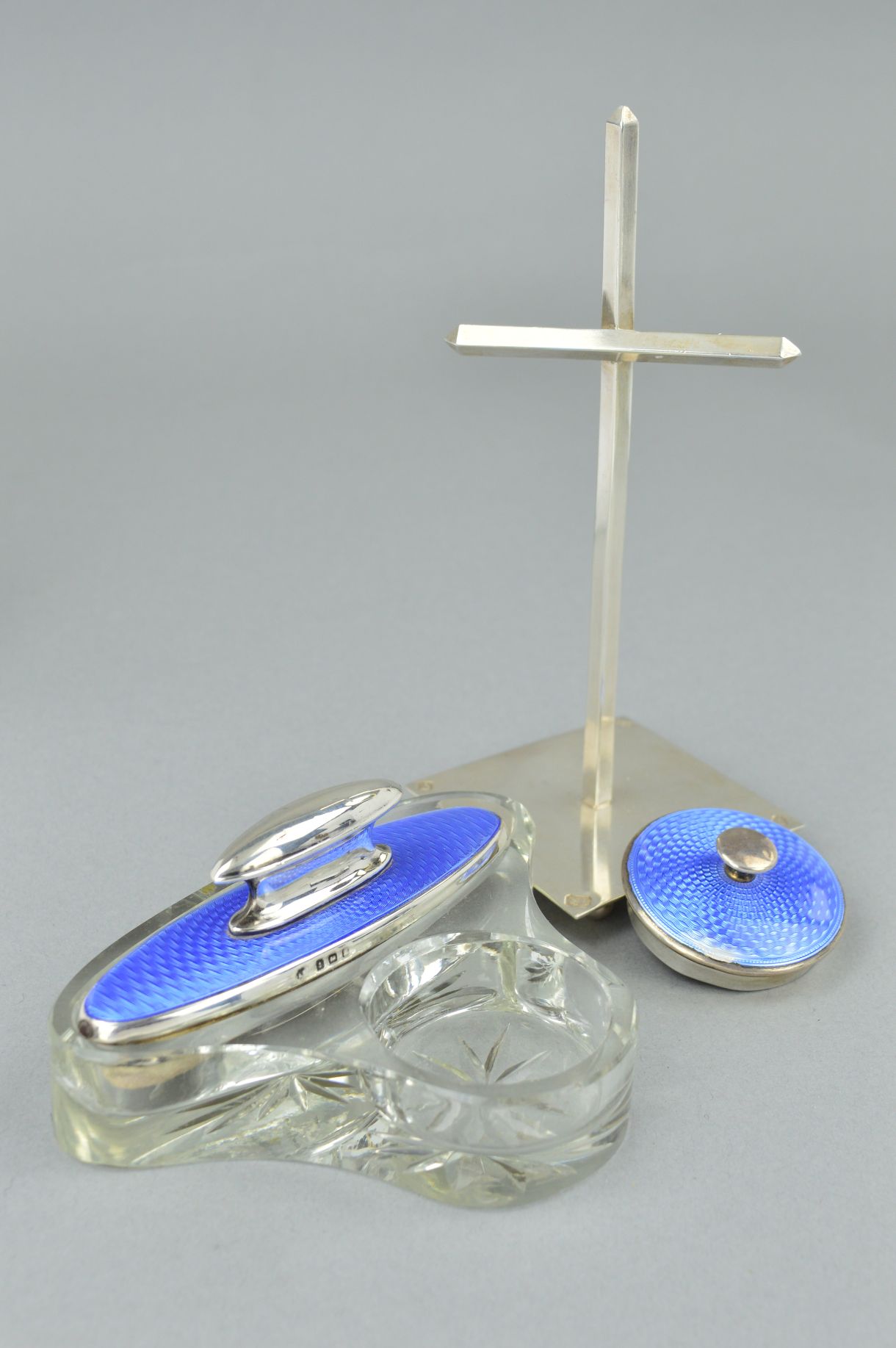 AN ENAMEL DRESSING TABLE SET AND A HARROW SCHOOL OF ART SILVER CROSS STAND, the dressing table set