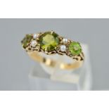 A LATE 20TH CENTURY PERIDOT AND SEED PEARL HALF HOOP RING, fancy scroll design sides and