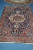 A 20TH CENTURY WOOLLEN CAUCASION RUG, red and deep blue ground, with foliate design, 205cm x