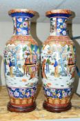 A PAIR OF LARGE ORIENTAL TRANSFER AND PAINTED VASES ON WOODEN STANDS, decorated with five scenes