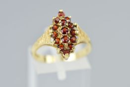 A 9CT GOLD GARNET RING, the tiered cluster of navette shape outline, claw set with circular cut