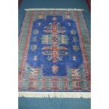 A 20TH CENTURY SILK GROUND RUG, blue ground, geometric detail and multi strap border, approximate
