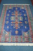 A 20TH CENTURY SILK GROUND RUG, blue ground, geometric detail and multi strap border, approximate